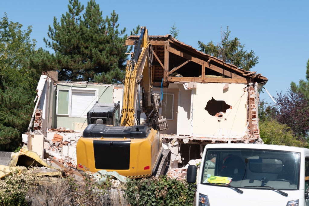 house demolition demolishing building with a large backhoe